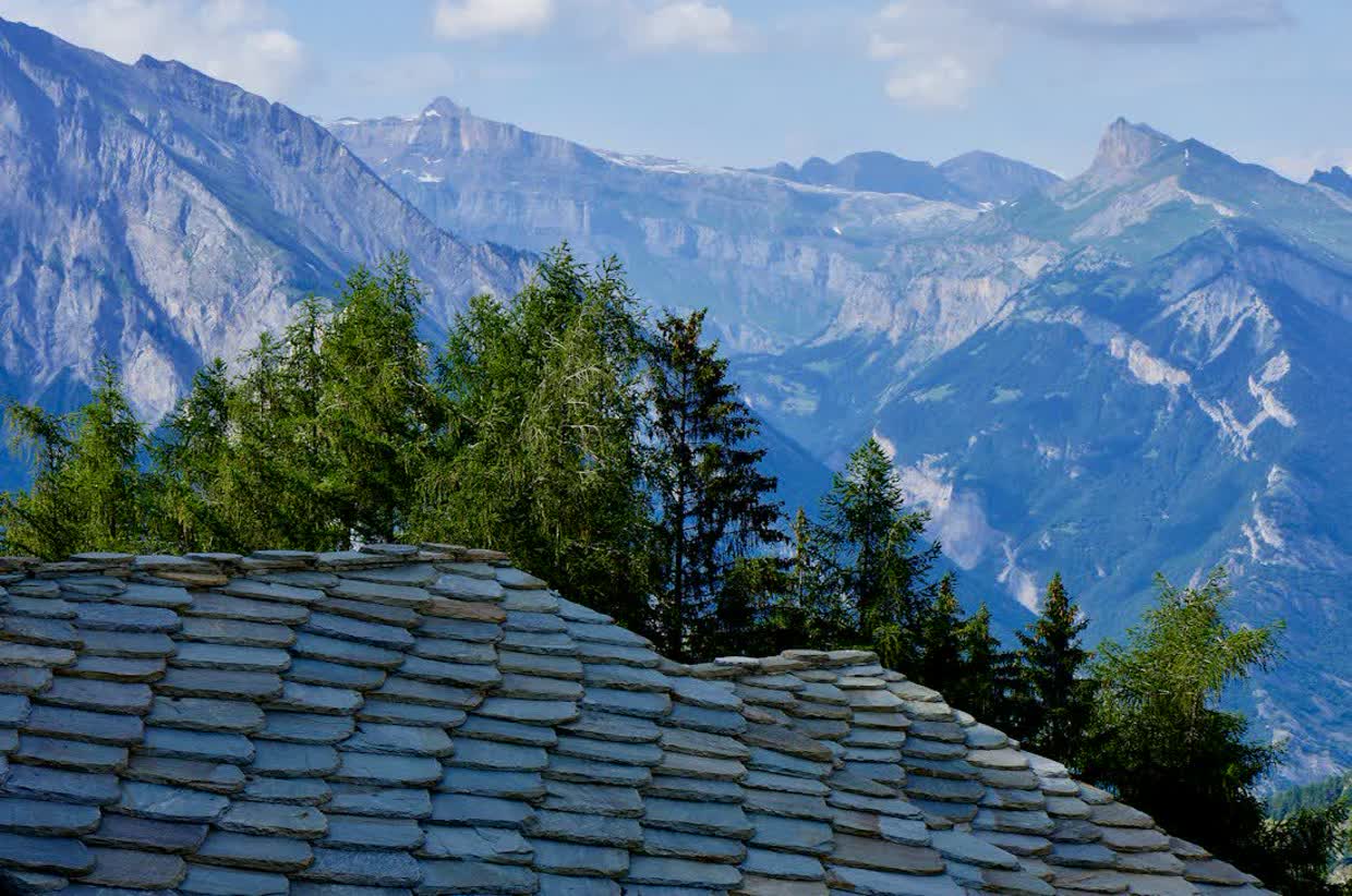 Dach aus Steinschindeln vor einer Bergkette